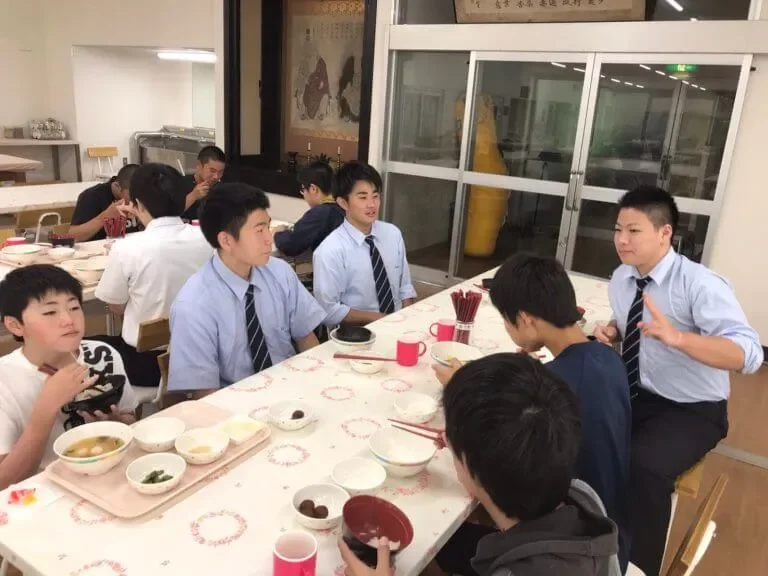 寮で食卓を囲む生徒たち